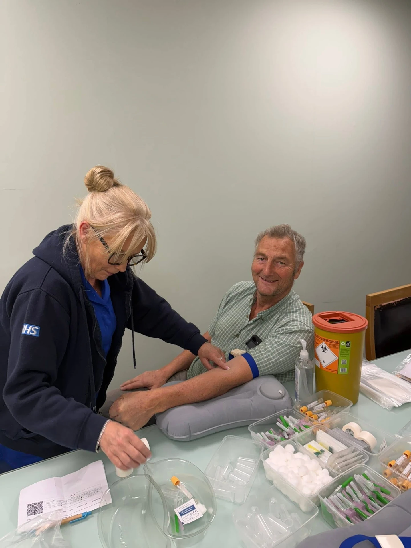 An NHS nurse taking a blood sample from a man at a PSA testing event