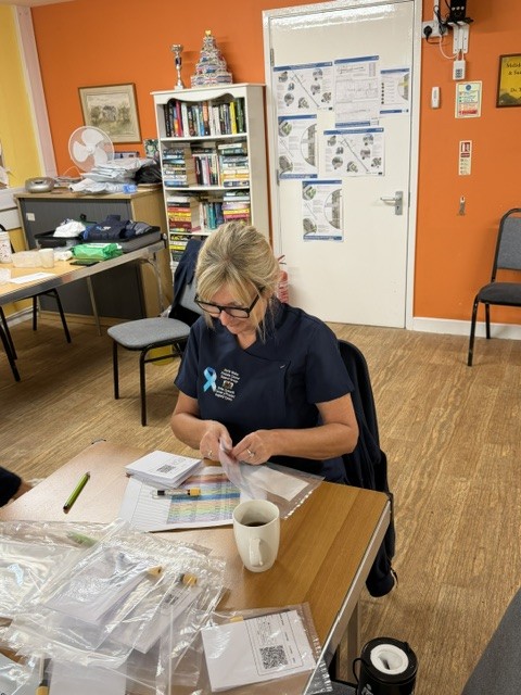Treasurer Cath ensuring the blood bottles are completed in full